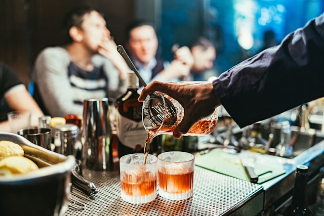 Bartender häller upp drinkar under kvällsrusningen
